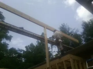Carpenter setting a ridge beam over a new addition frame — Ice Dam Removal by Roofing Brothers in Merion Station