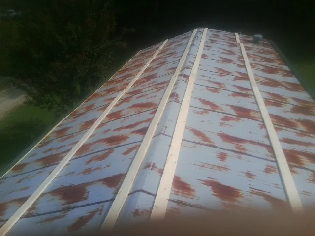Rusted metal roof panels with new wood purlins before replacement — Storm Damage Roof Repair in Merion Station by Roofing Brothers