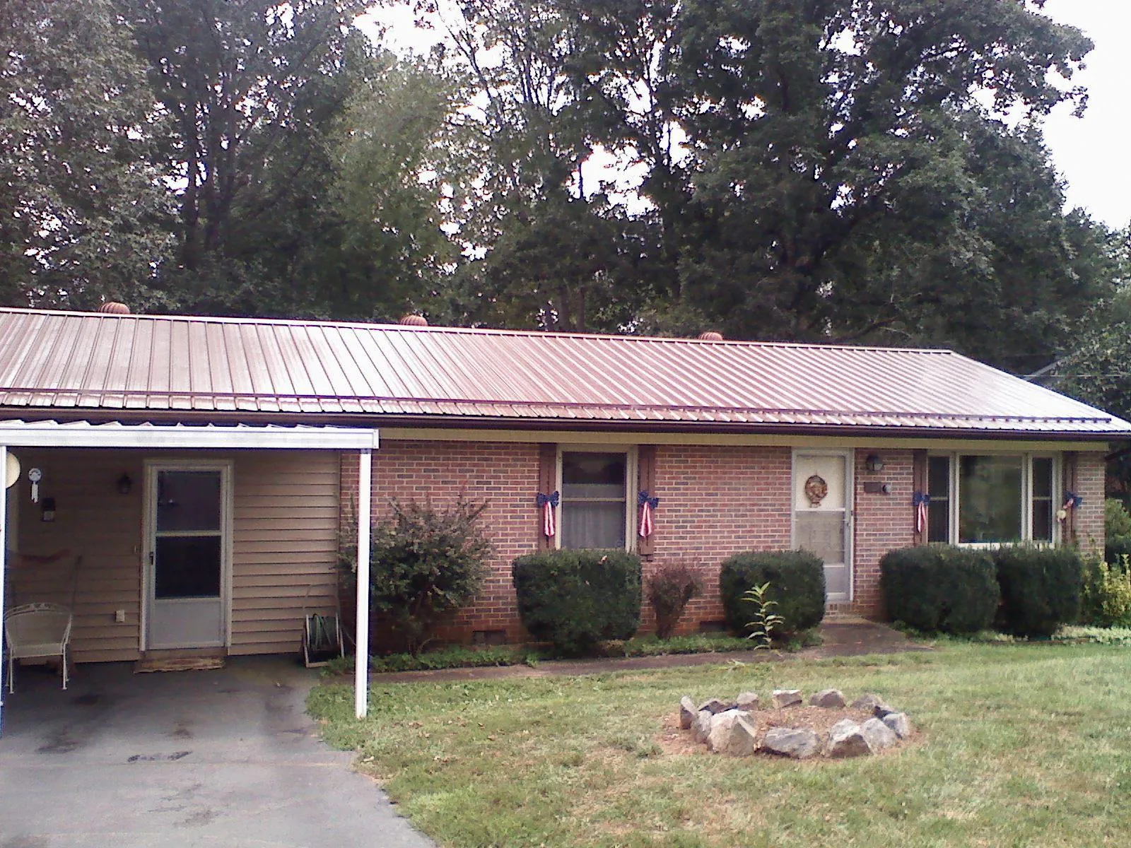 Bronze metal roof and carport on a brick ranch home — Roof Repair work by our crew in Merion Station